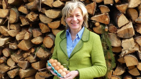Bäuerin Rosmarie Böswirth vor Holz mit Eiern