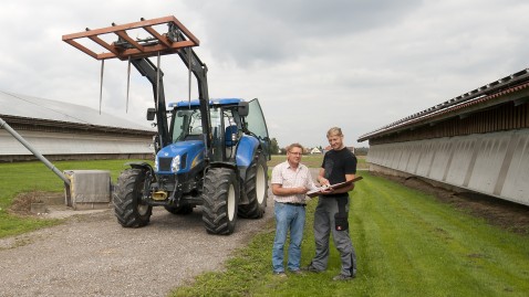 Zwei Landwirte unterhalten sich auf einem Bauernhof.