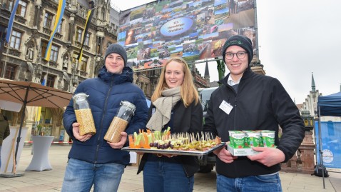 Junge Landwirtinnen und Landwirte bieten Produkte zur Verkostung an. 