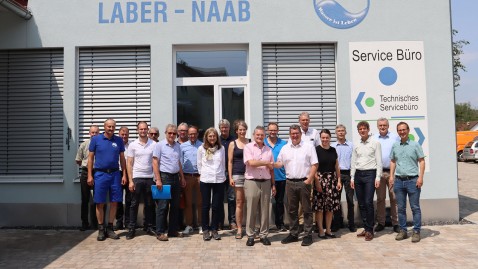 Gruppen von Menschen vor einem Bürogebäude