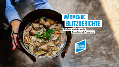 Ein Kochtopf mit Suppe, der in den Händen gehalten wird