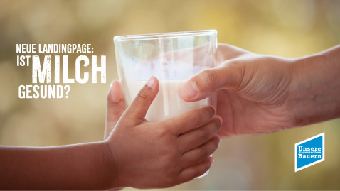 Zwei Hände halten ein Glas Milch