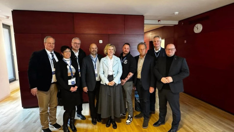 Mitarbeiter stehen vor einer roten Wand