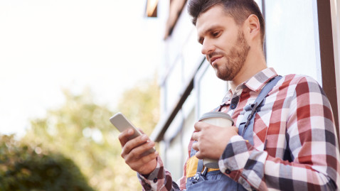 Junger Landwirt schaut in sein Handy