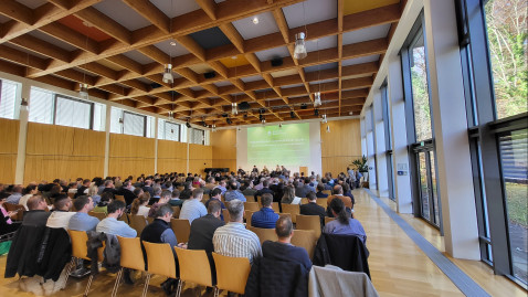 Blick durch Vortragsraum über Publikum zum Podium