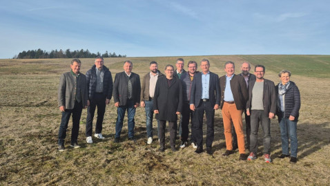 Teilnehmer der Bezirksversammlung auf einer Wiese, die mit Engerlingen befallen ist