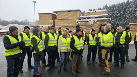 Teilnehmer an Betriebserkundung auf Sägewerksgelände