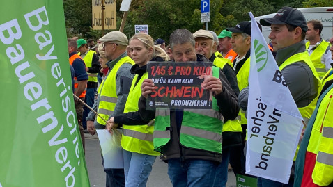 Demonstranten halten Schild in die Höhe.