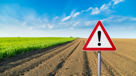 Acker mit Achtung-Schild
