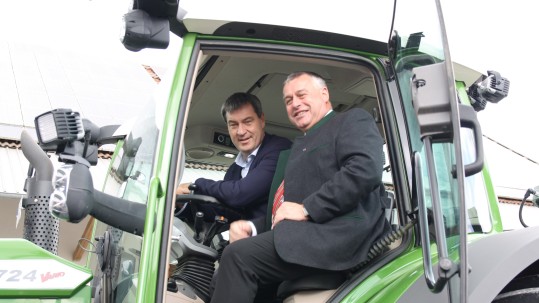 Bauernpräsident Heidl und Ministerpräsident Söder sitzen auf einem Schlepper mit RTK Signal