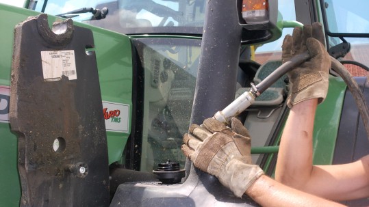 Eine Landwirtin füllt den Tank ihres Traktors