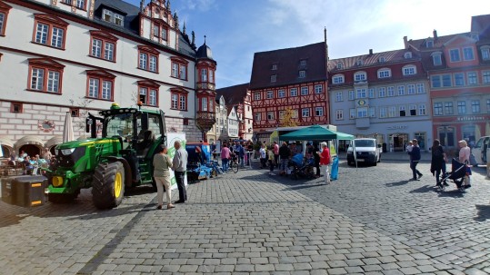 Schweinemobil, Traktor mit Sämaschine auf dem Marktplatz in Coburg