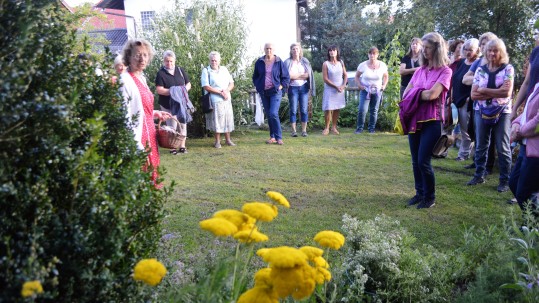 Gartenbäuerin Heidi Buchner (rotes Kleid) mit den Landfrauen in ihrem Garten