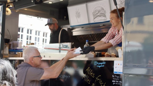 Foodtruck1 Passant nimmt Essen vom Foodtruck entgegen