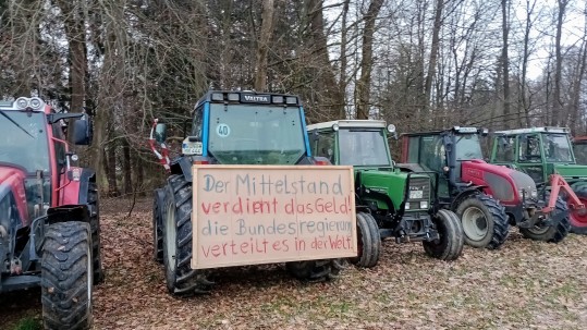 Schlepper mit Protesttafel an Frontseite