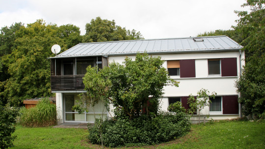 Ein Haus mit Balkon im Grünen