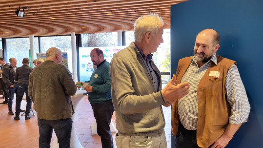 Zwei Männer im Vordergrund unterhalten sich