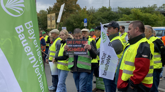 Demonstranten halten Demoschild in die Höhe. 